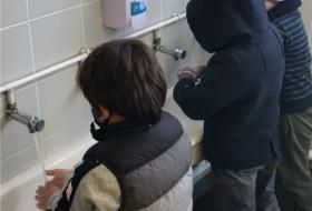 Des petits garçons se lavent les mains dans les toilettes d’une école.