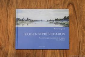 Photo de la couverture de l’ouvrage « Blois en représentation » de Bruno Guignard, figurant une peinture du paysage de Blois depuis la Loire, au premier plan, avec le pont Jacques-Gabriel au loin, Blois-Vienne à droite et le centre-ville à gauche.