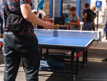 Des personnes jouent au ping pong dans la rue.