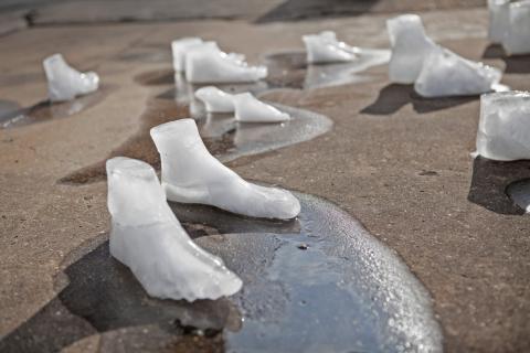Des sculptures de glace en forme de pieds fondent au soleil.