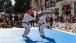 Deux personnes font du judo sur un grand tapis installé dans la rue.