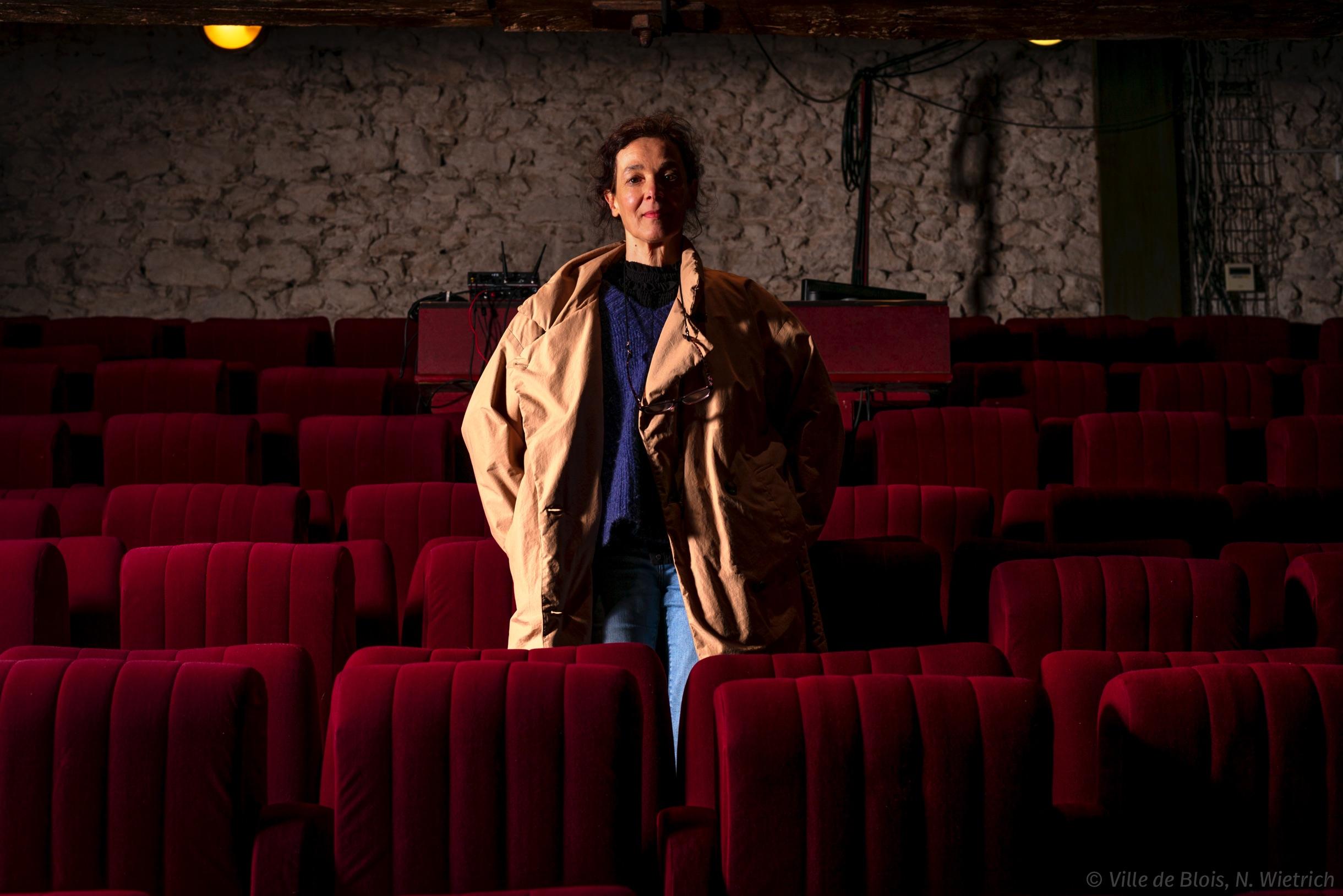 Portrait de Danièle Marty, au milieu de sièges de théâtre vides.